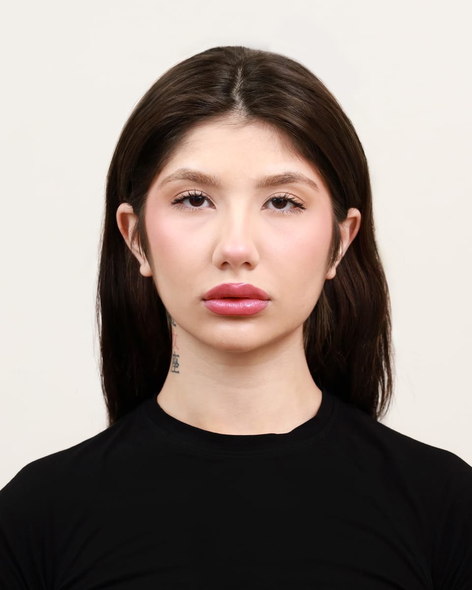 Professional headshot of Asal Dabbaghchian, Toronto-based model and UGC creator, in a black tee against a cream studio wall